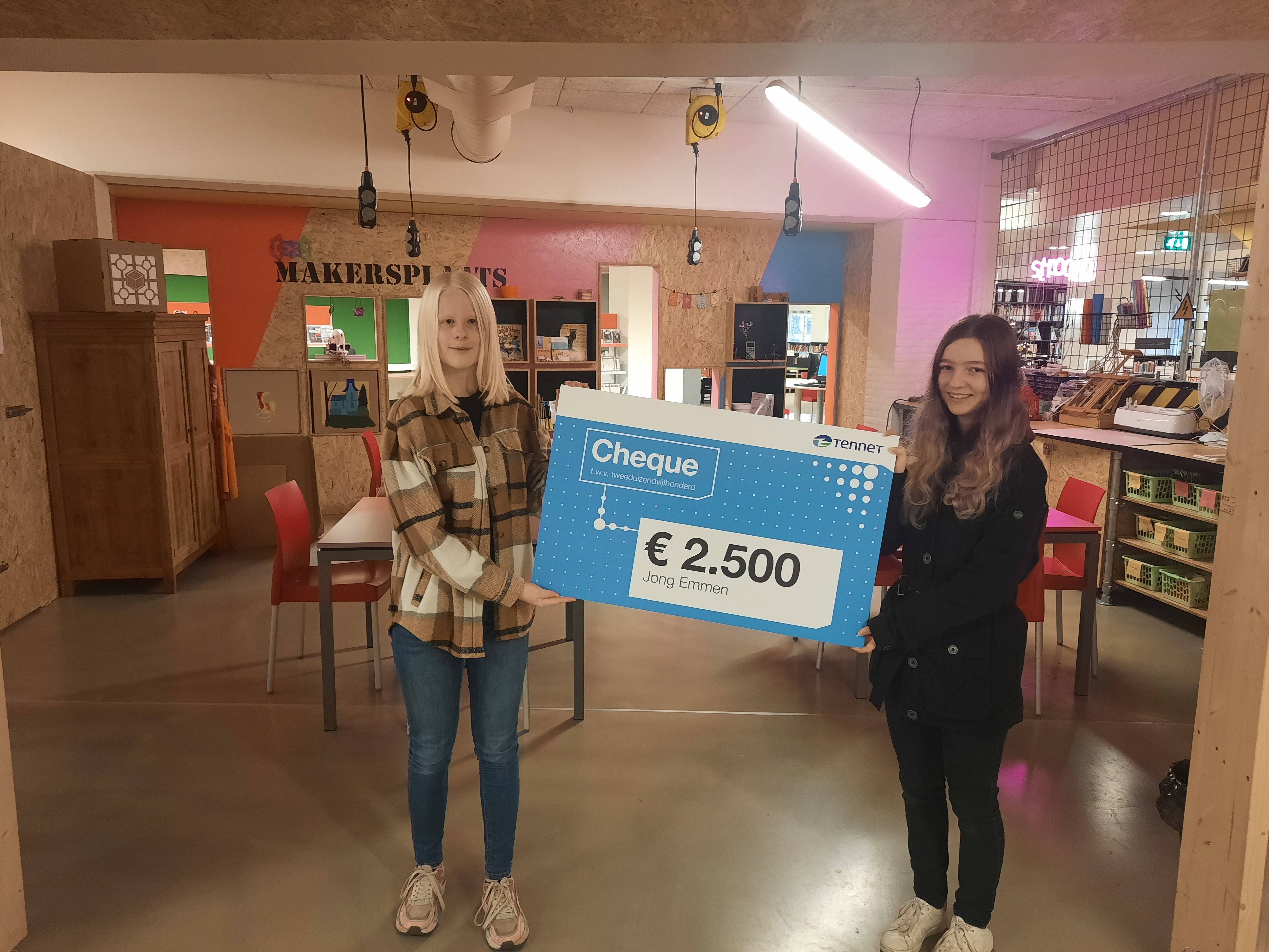 Kyra en Mirte nemen cheque in ontvangst.