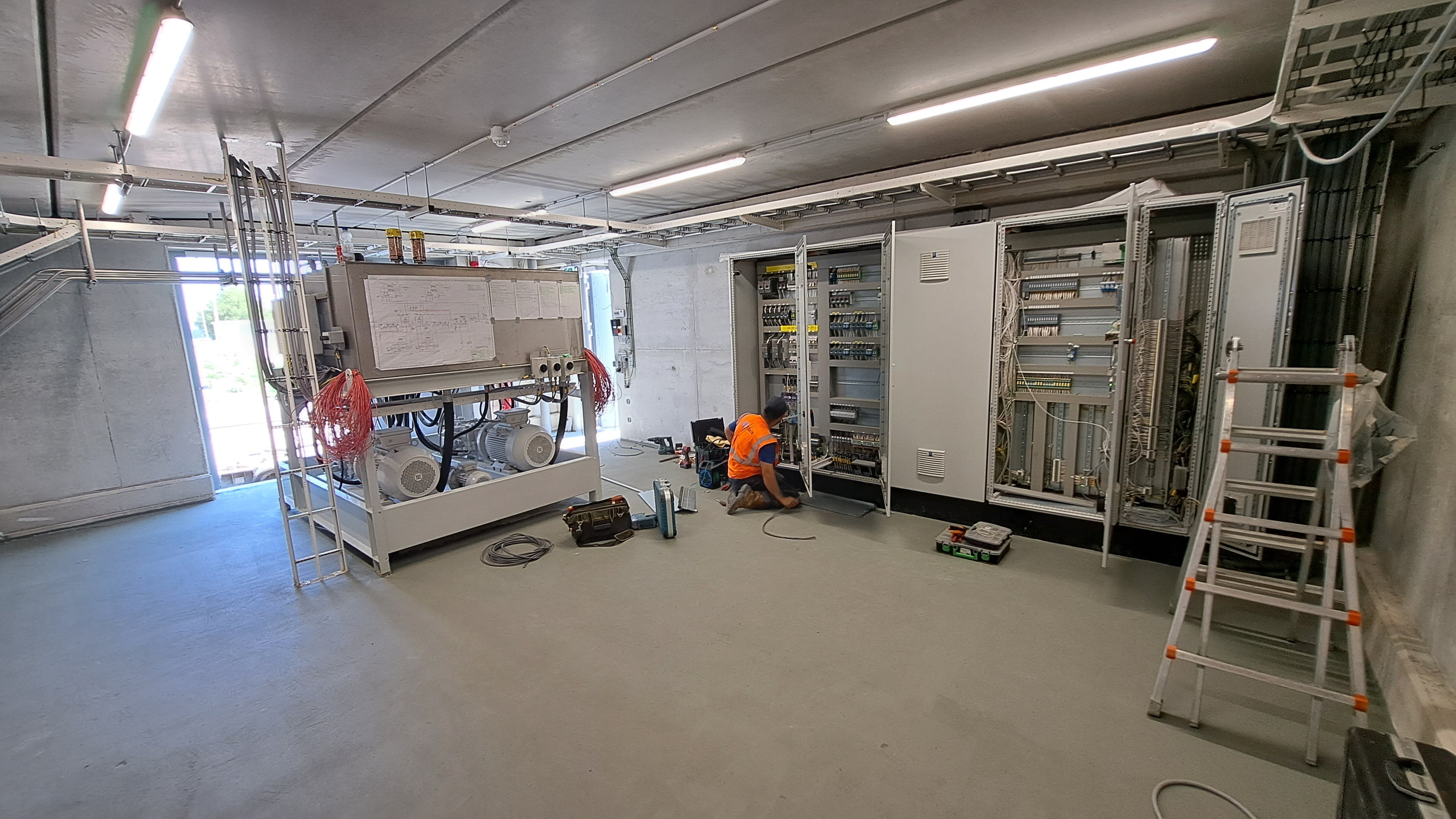 Foto 3: Monteur bezig met werkzaamheden in de schakelkasten binnen in de technische ruimte.