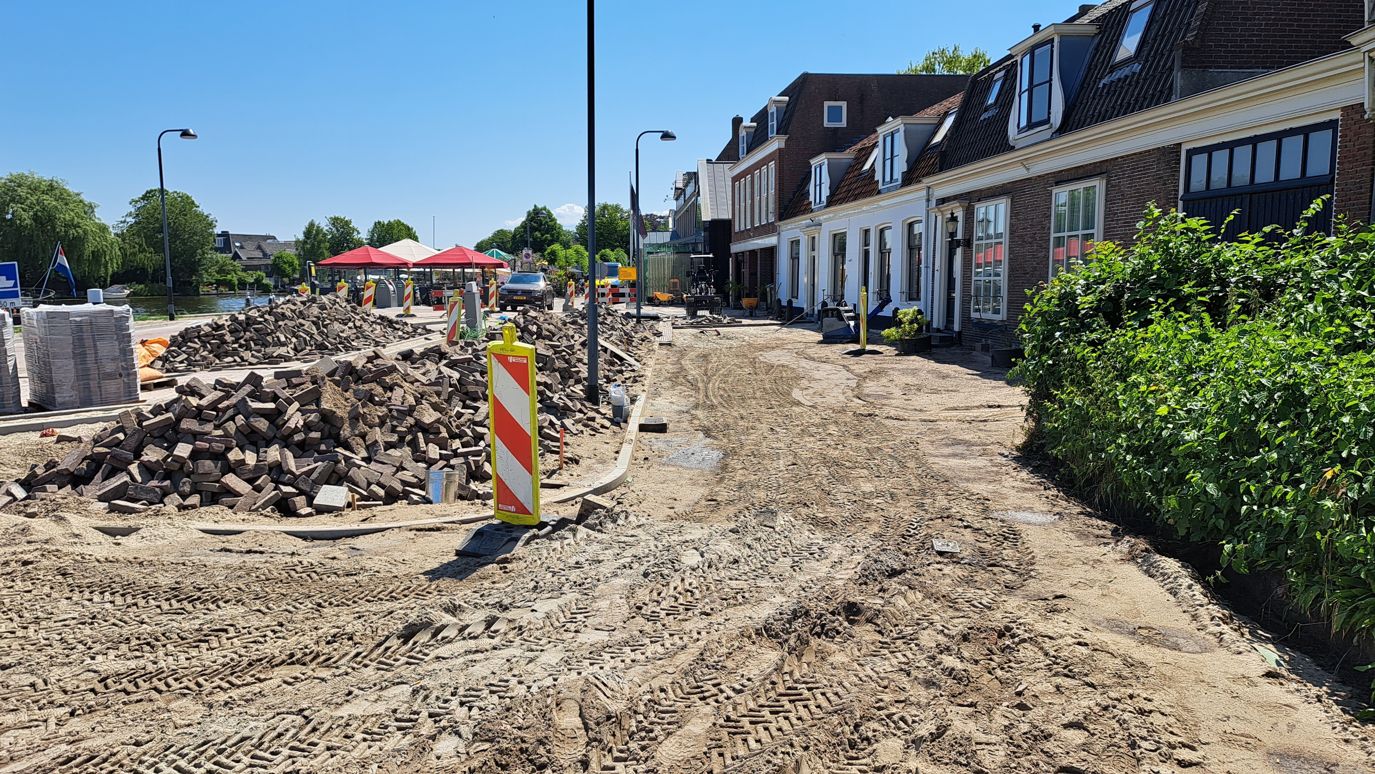 Foto 7: Zand ligt klaar voor het straatwerk langs de woningen aan de Amstelzijde.