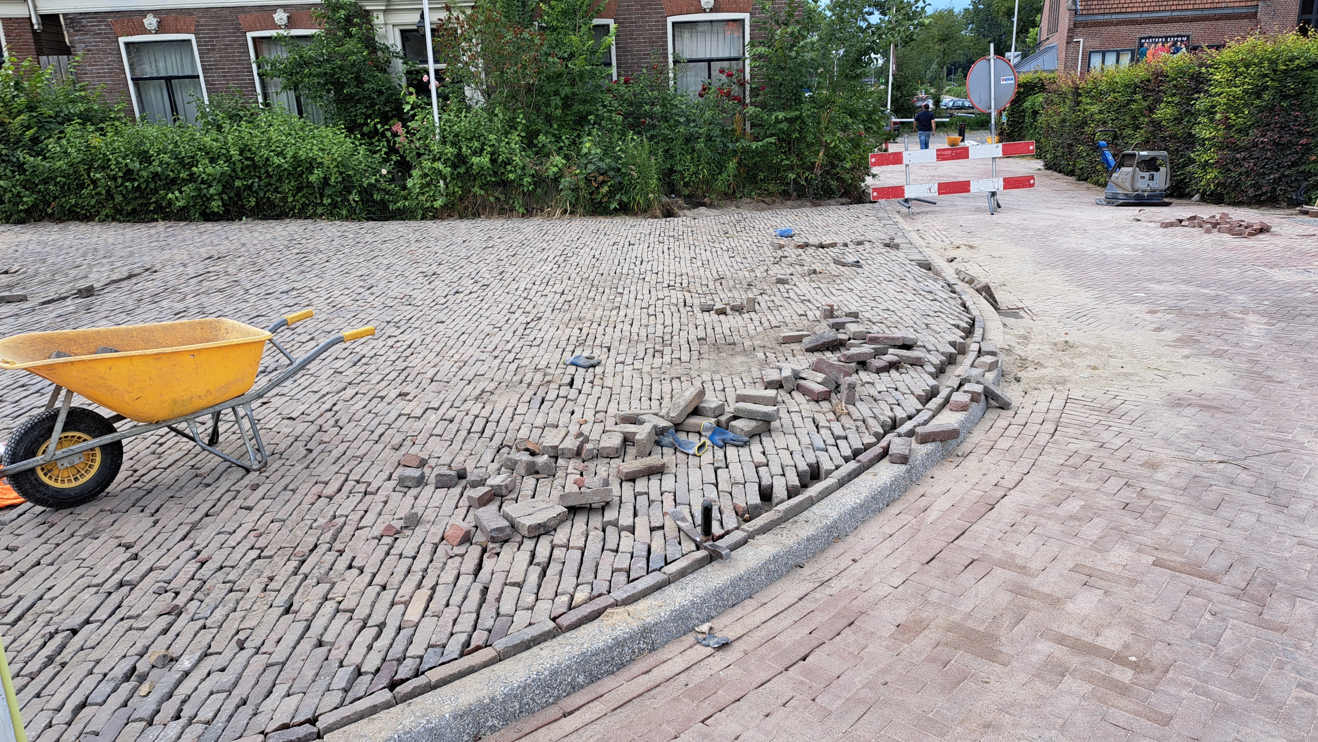 Foto 2: De laatste stukjes straatwerk worden dicht gestraat op Amstelzijde.