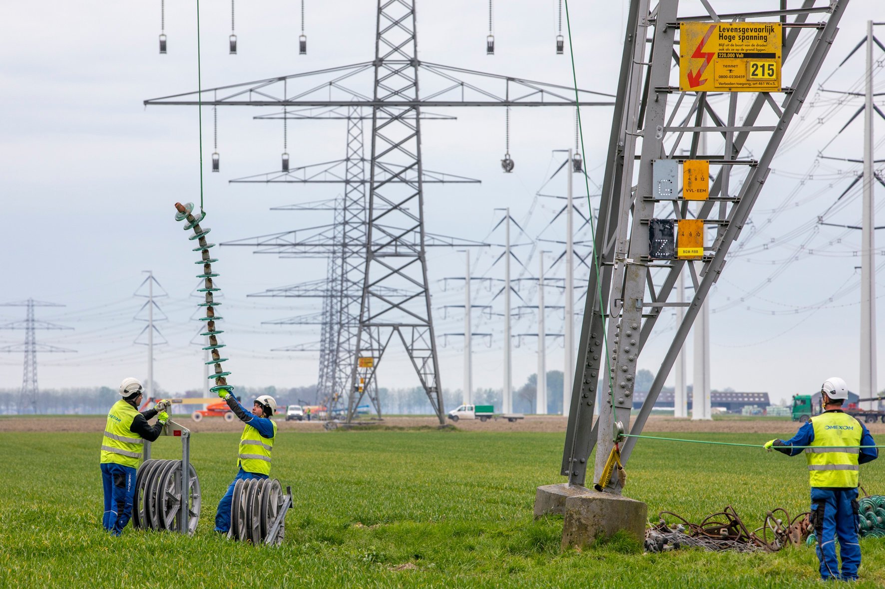 Harde werkers van Omexom bij het in-en uithangen van de katrollen. Nodig voor het uithalen van de geleiders.