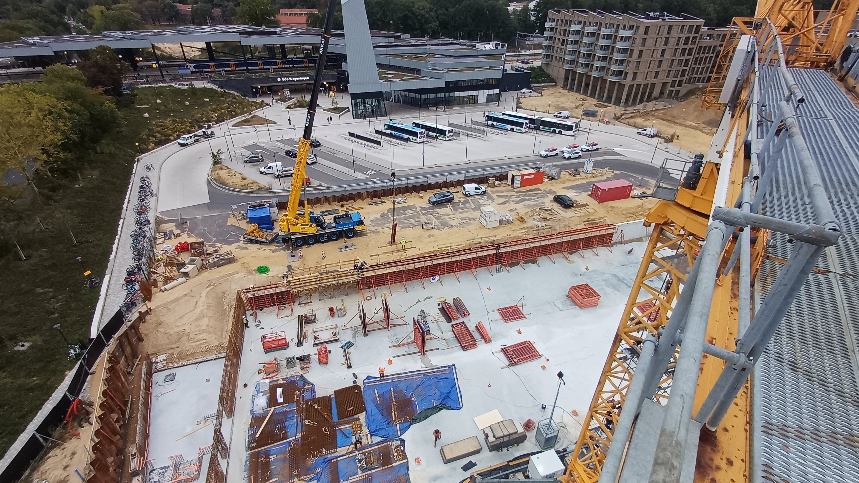 Uitzicht vanuit de torenkraan op de bouwplaats en op de achtergrond het busplein en het station