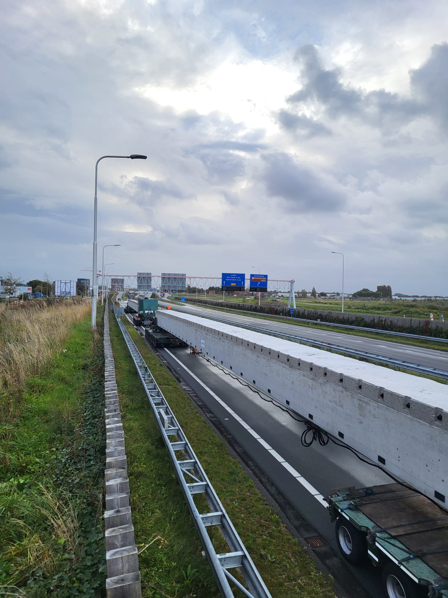 De bijna 50m lange betonnen liggers zijn met exceptioneel transport op locatie aangekomen.