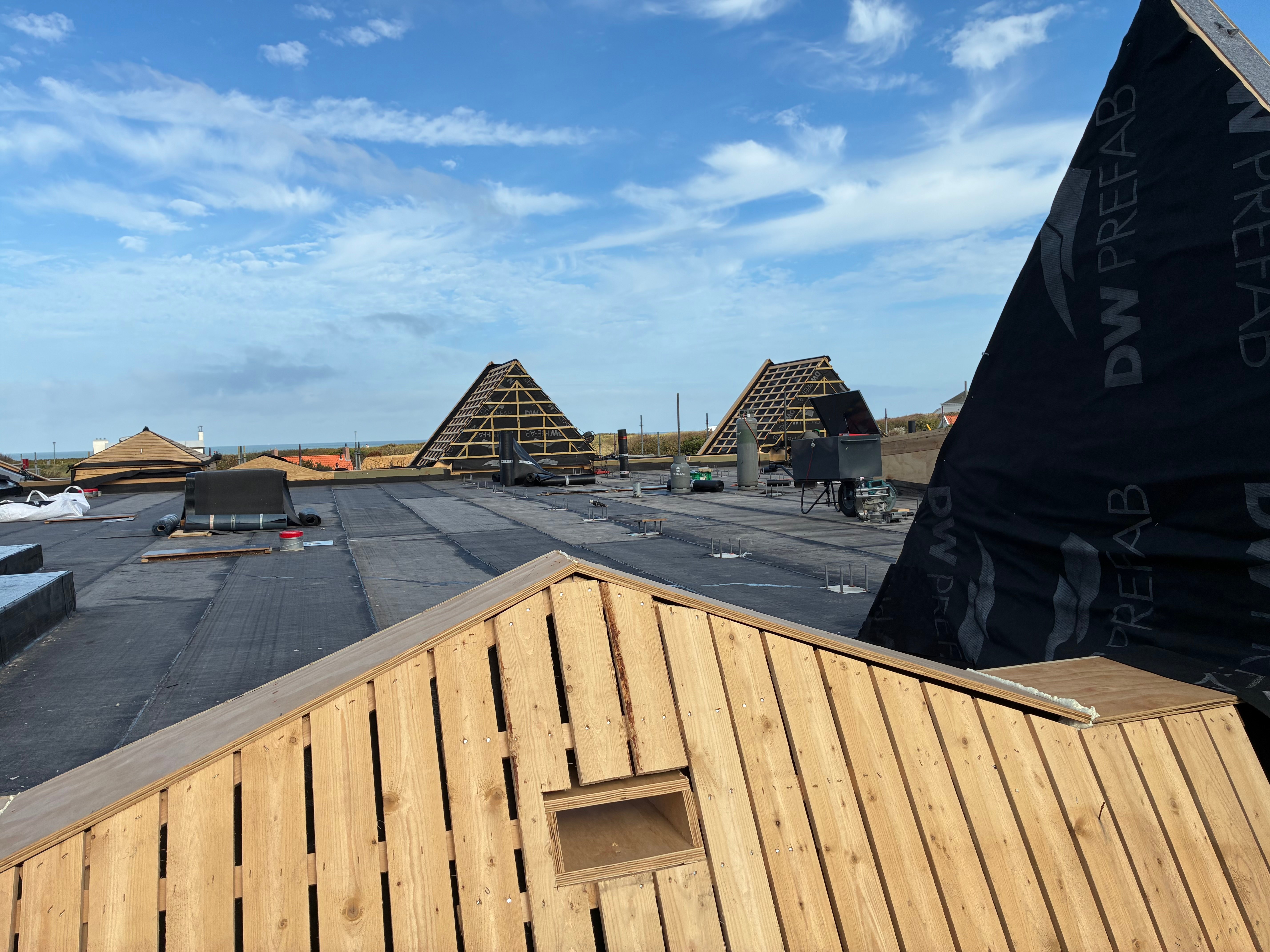 De noodlaag op het betondak tussen de schuine daken