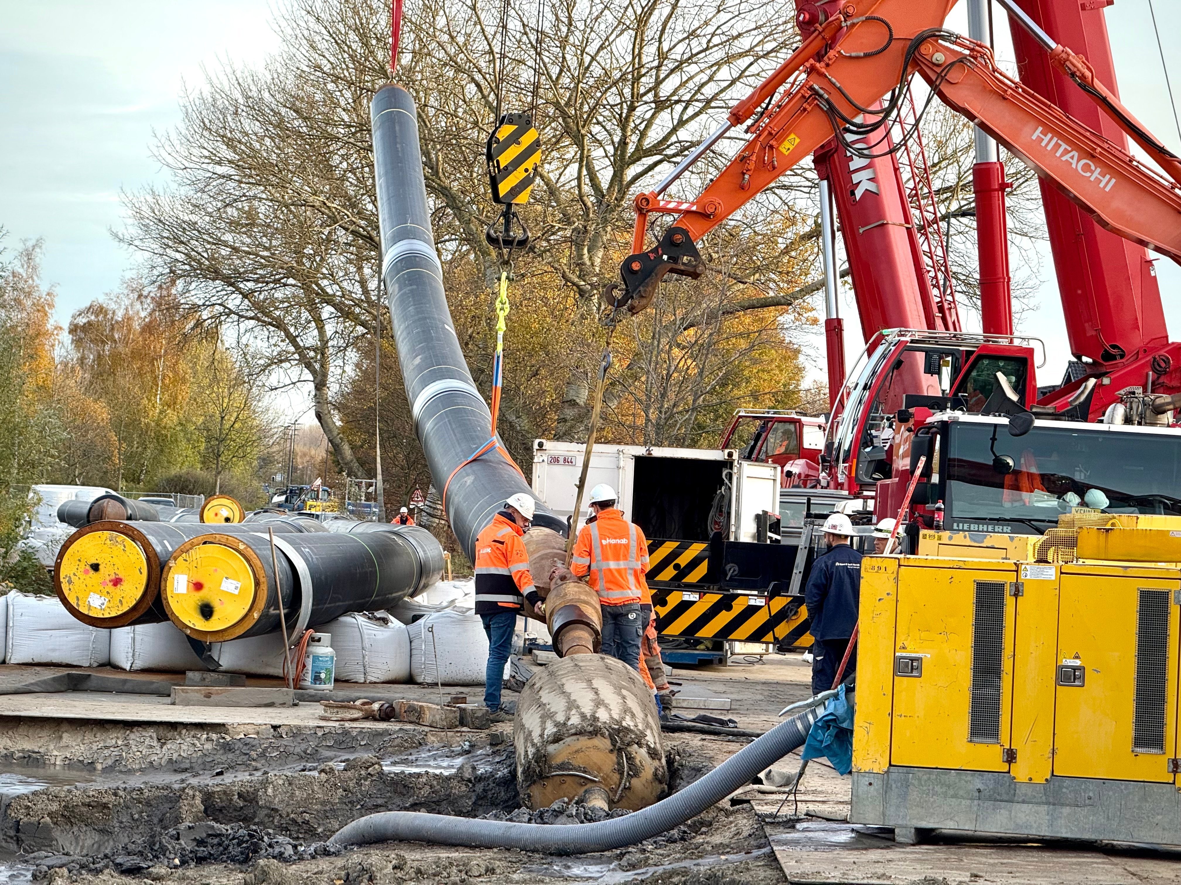 Eerste stuk leiding van 48 meter lang hangt in de kraan. Voorop is de leiding gekoppeld aan de boorstangen die door de machine bij Marnix Revalidatiecentrum ondergronds wordt terug getrokken.