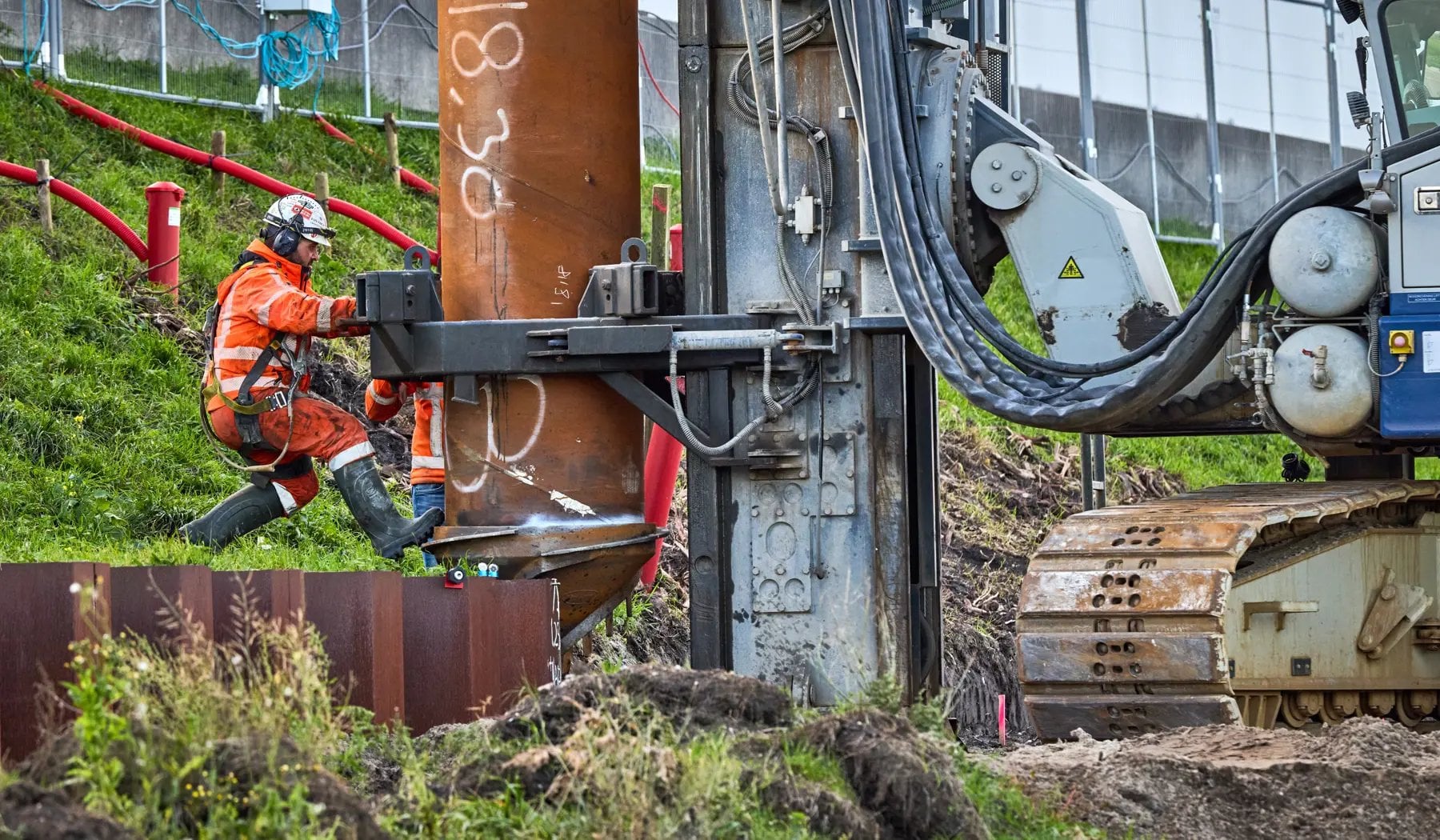 De eerste paal wordt naar zijn plek gebracht om de grond in te gaan