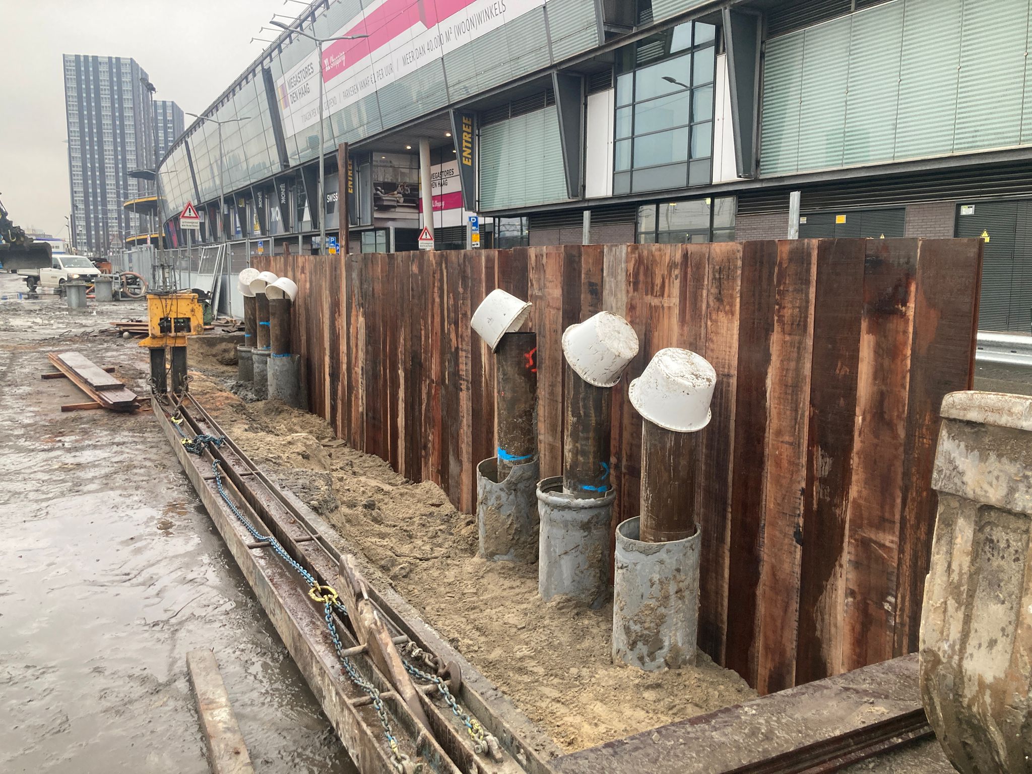De palen en damwanden aan de rand van het bouwterrein voor de fundering van 1 torenkraan zitten in de grond