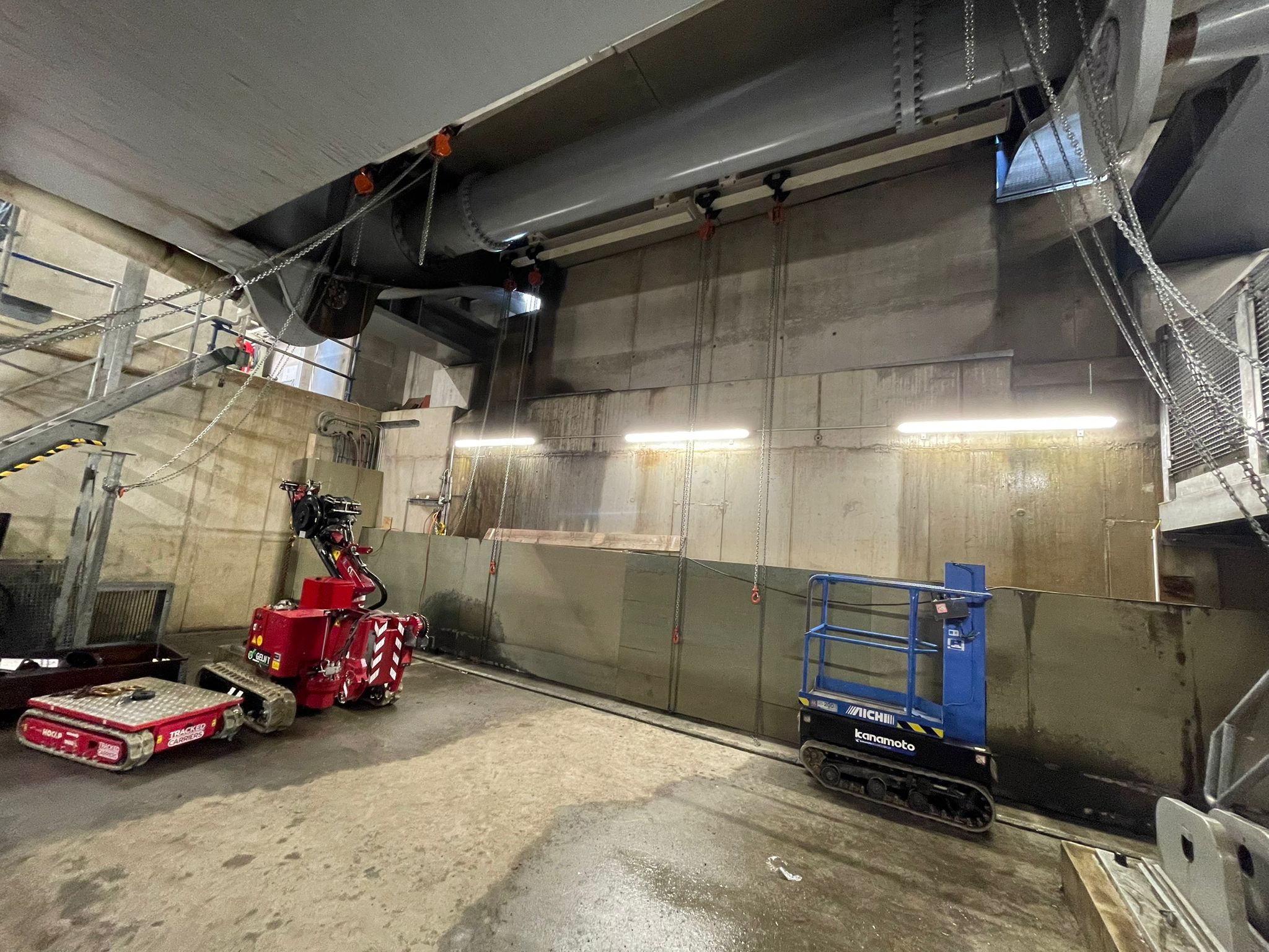 Mini-materieel op rupsen zijn in de basculekelder geplaatst. Na aanbrengen hulpbrug kan gestart worden met verwijderen van bestaande koppelbuis (grijs).