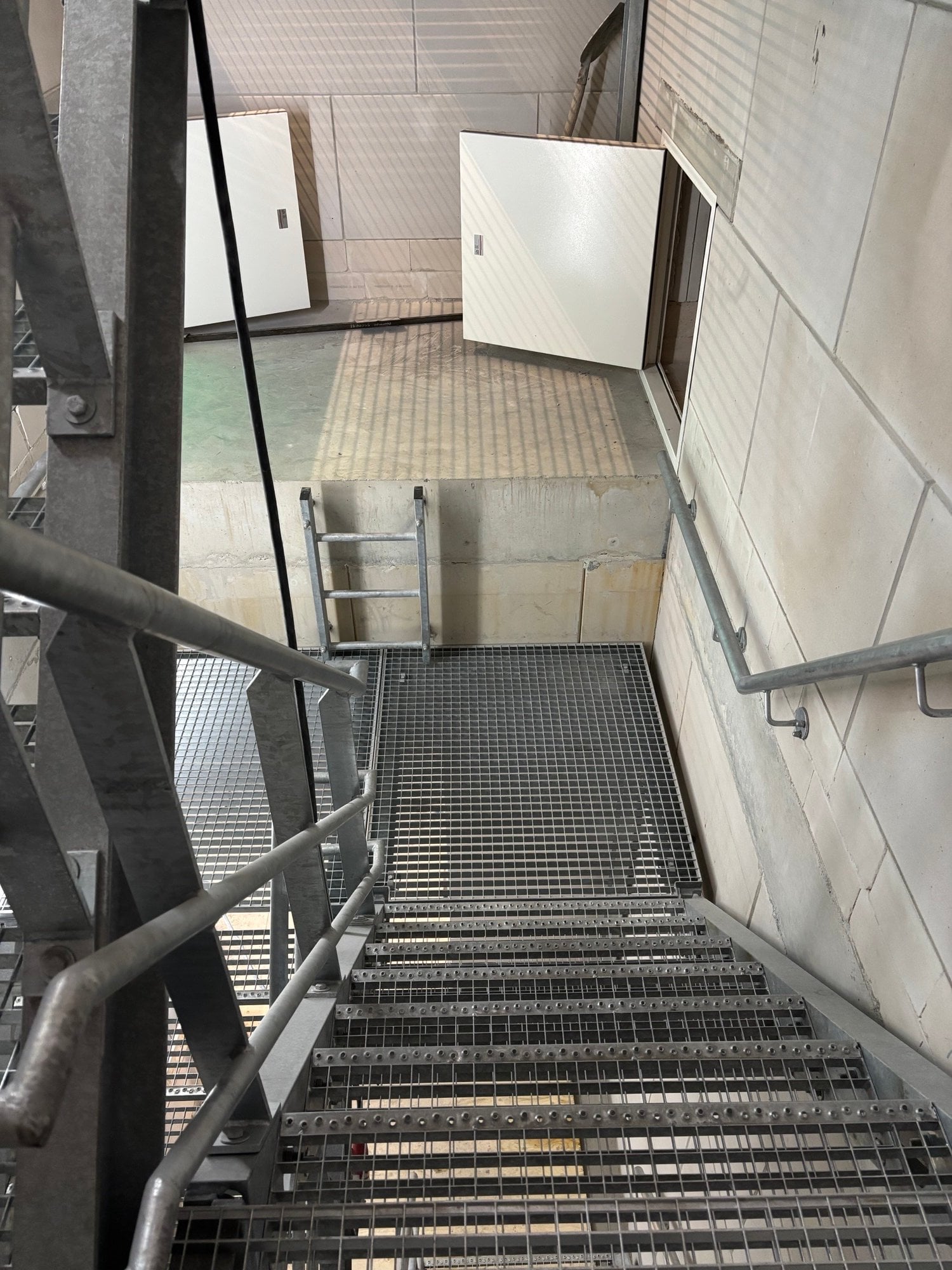 De trap in het bedieningsgebouw met onderaan de luiken, zodat medewerkers onder de vloeren kunnen komen.