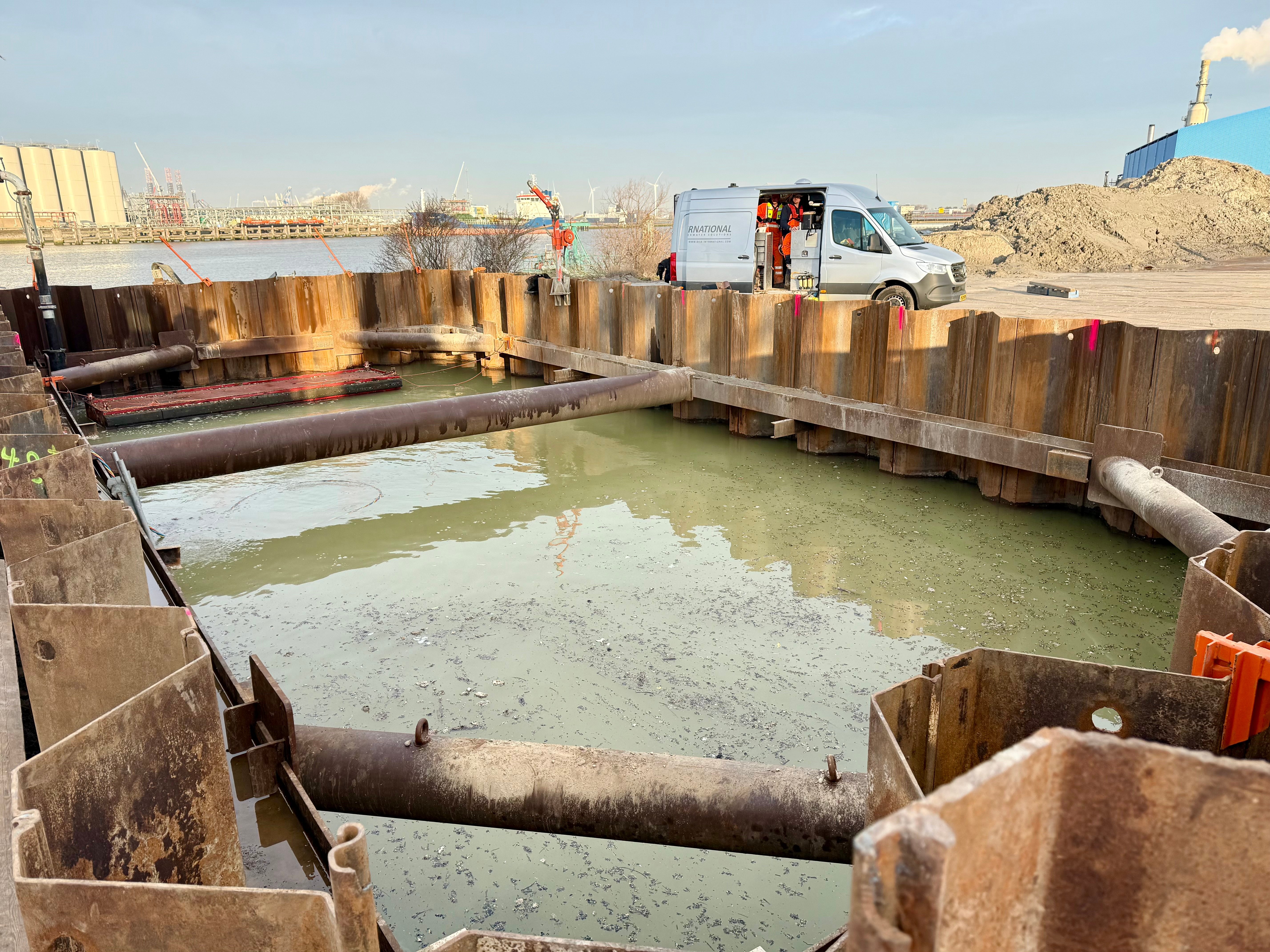 De bouwkuip staat nu nog onder water. Zodra het beton is uitgehard dan pompen we de bouwkuip leeg en kunnen we van start met de boring onder de Vondelingenweg.