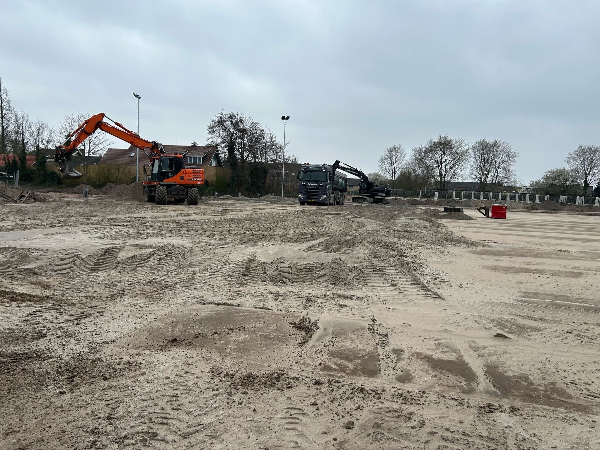 Ophogen van het kunstgrasveld met zand