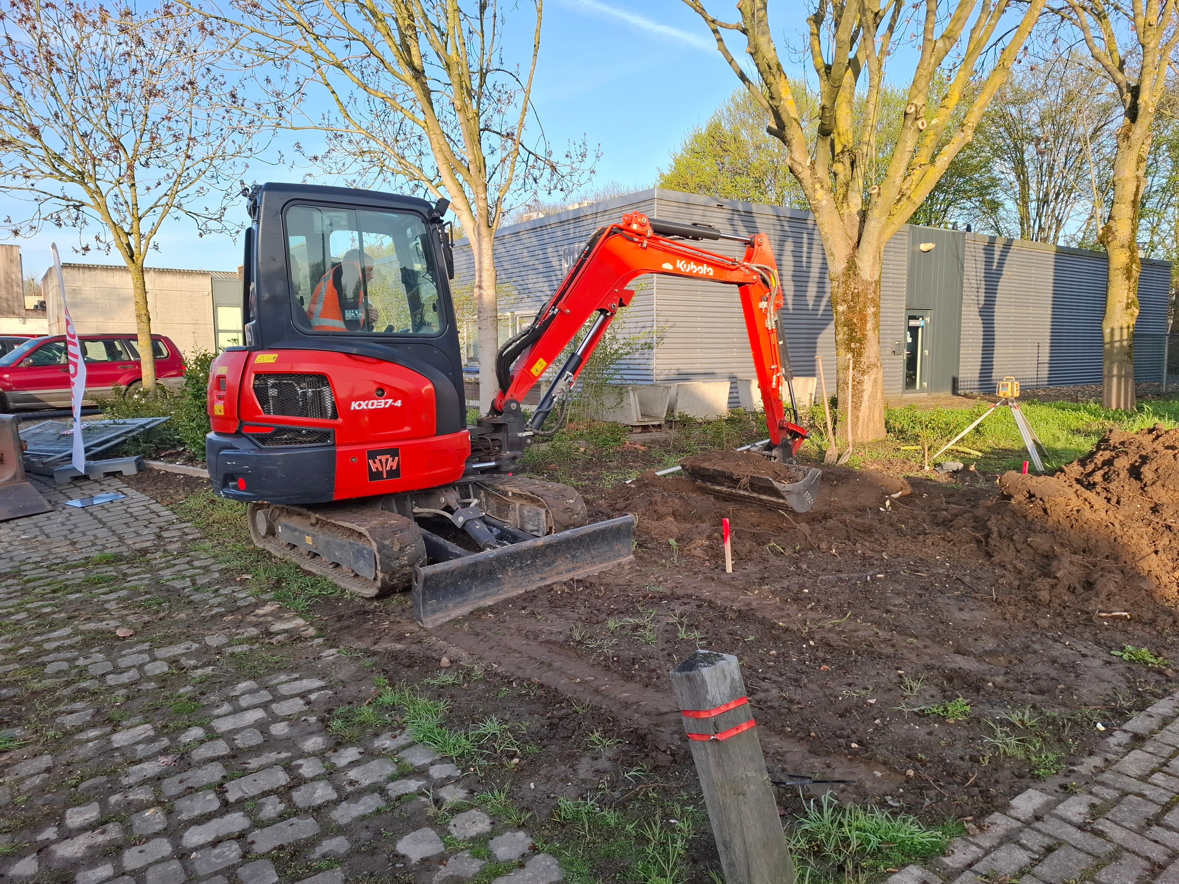 Met een graafmachine en een kantenschop wordt de fundering uitgegraven. Daarna komt er een zandbed in.