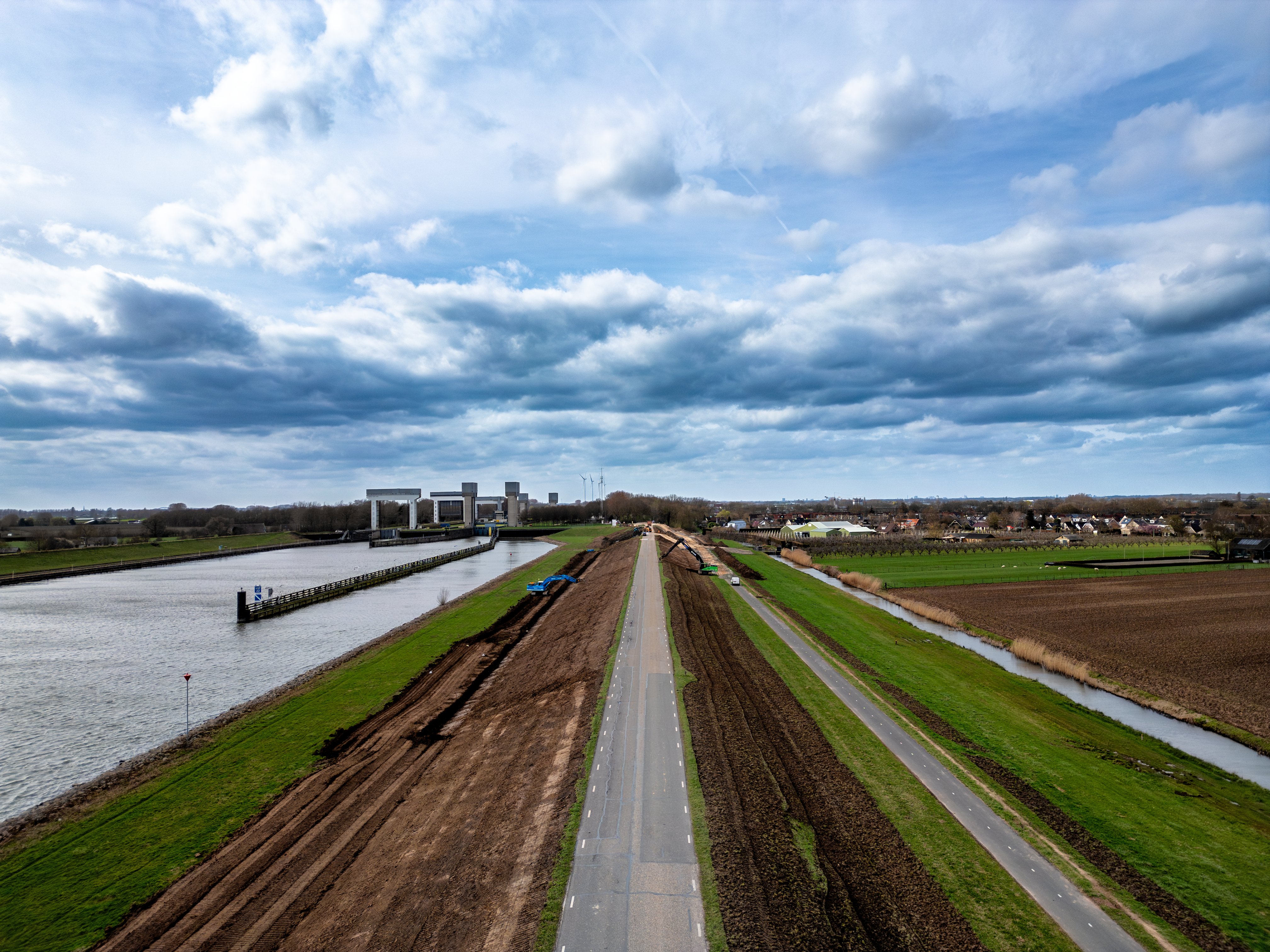 Bovenaanzicht van de Lekdijk Oost, waar aan beide zijden van de dijk grondwerk wordt uitgevoerd.
