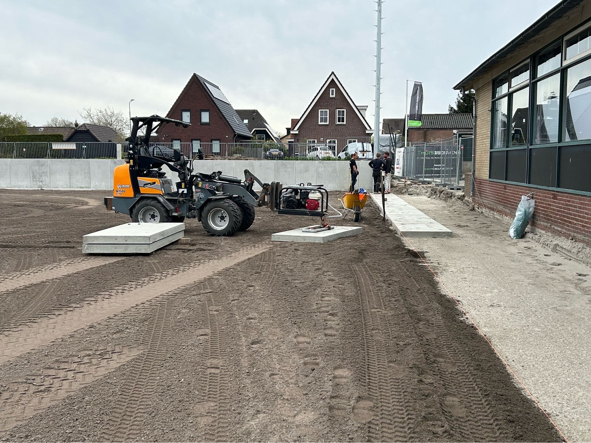 Aanbrengen van betonplaten rondom het kunstgrasveld
