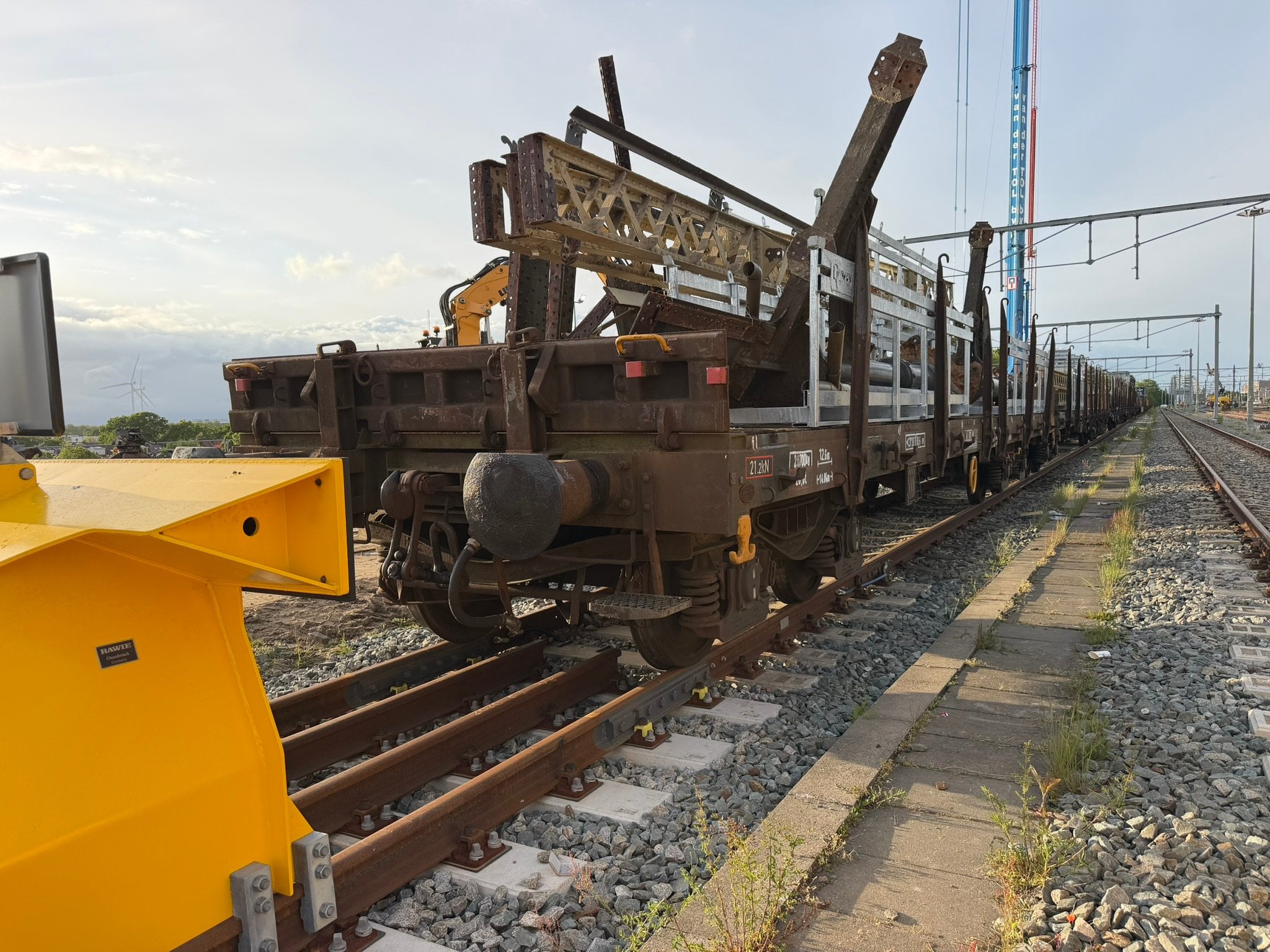 Werktrein met stalen constructie van perronkap staat gereed voor vertrek