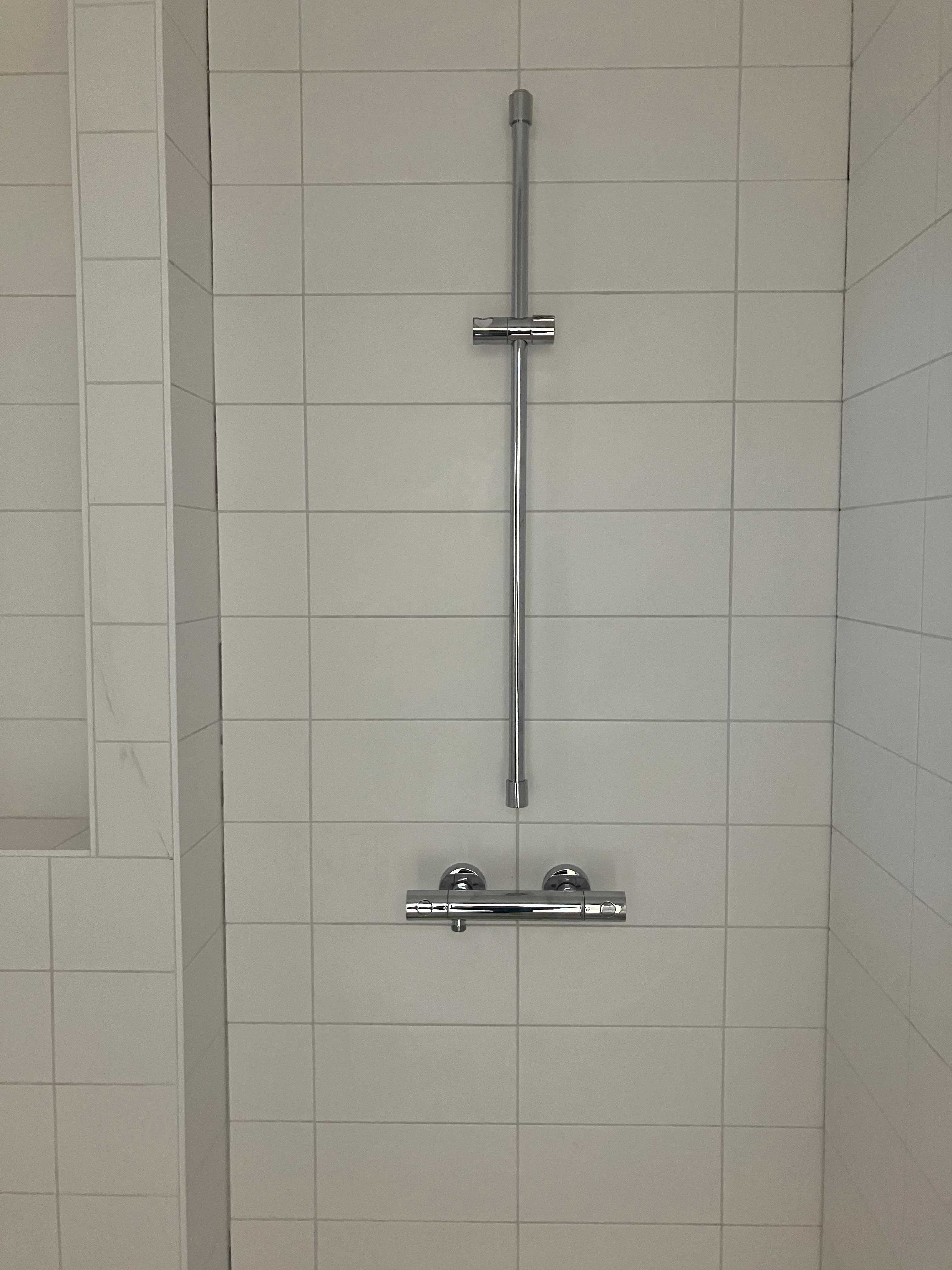 De installaties worden afgemonteerd. Op de afbeelding is een douchestang in de badkamer te zien.