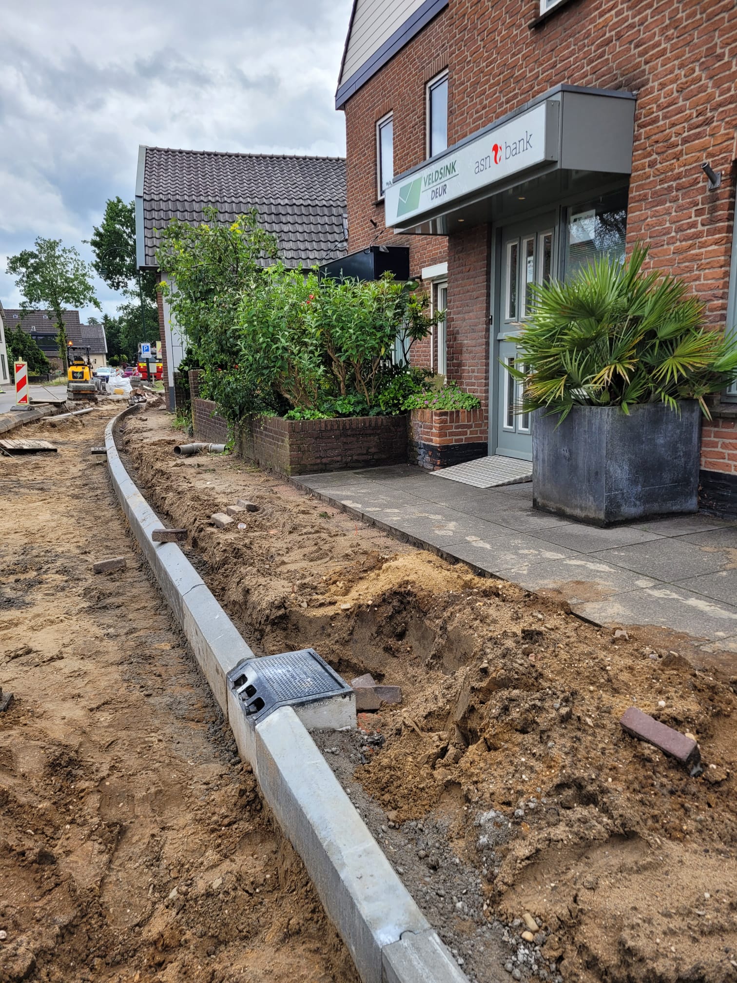 Nieuwe stoepranden en putten ter hoogte van de Uitweg.