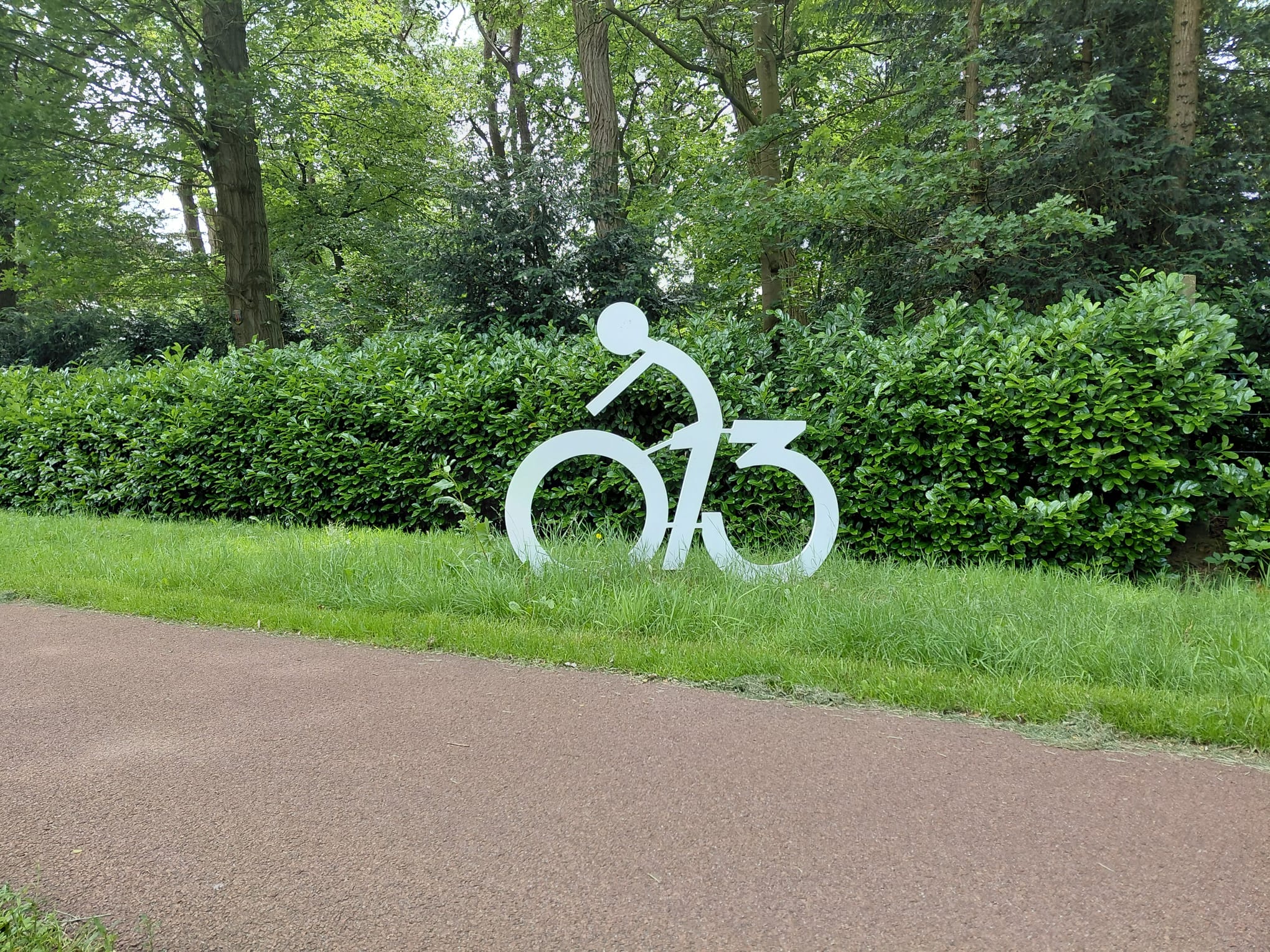 Op de afbeelding is een object te zien dat naast het fietspad staat van de Gilzerbaan. Dit geeft een fietsroute of een recreatief fietspad aan.