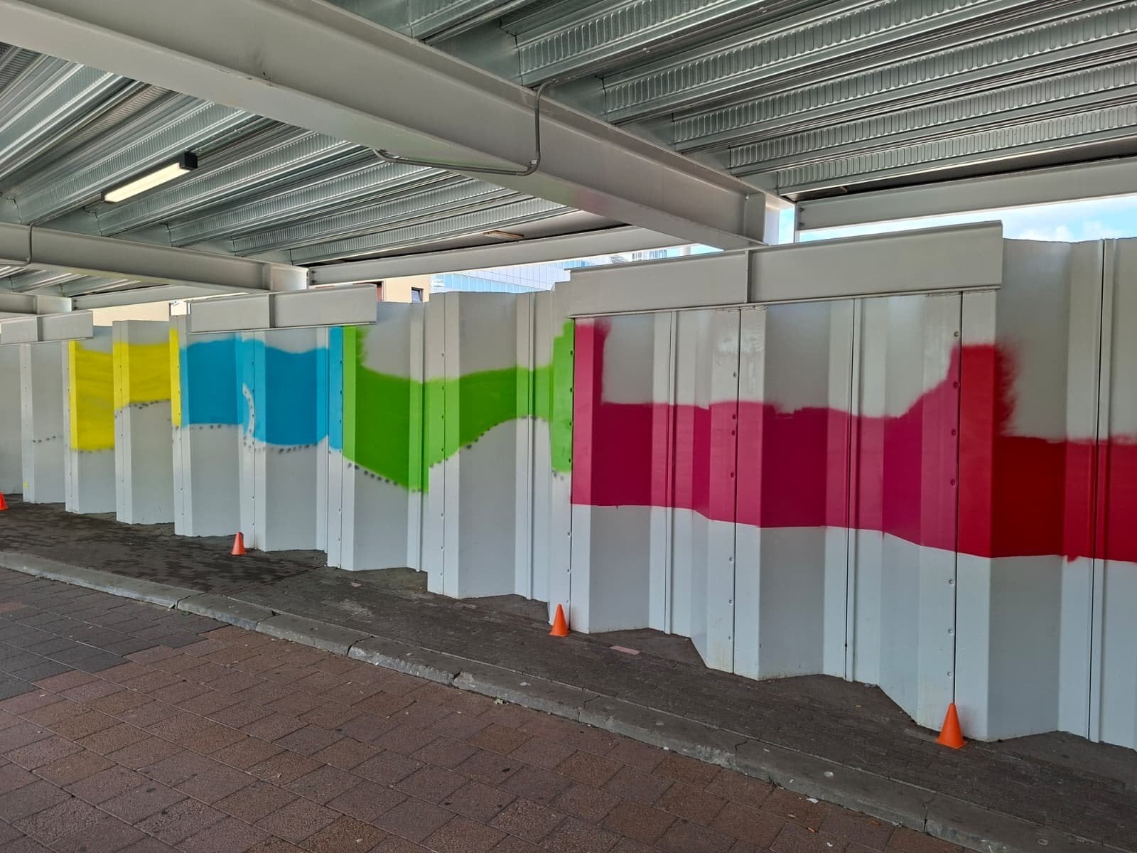 De eerste kleuren en contouren van het ontwerp worden zichtbaar op de damwanden in de overkapping van de stationstunnel.