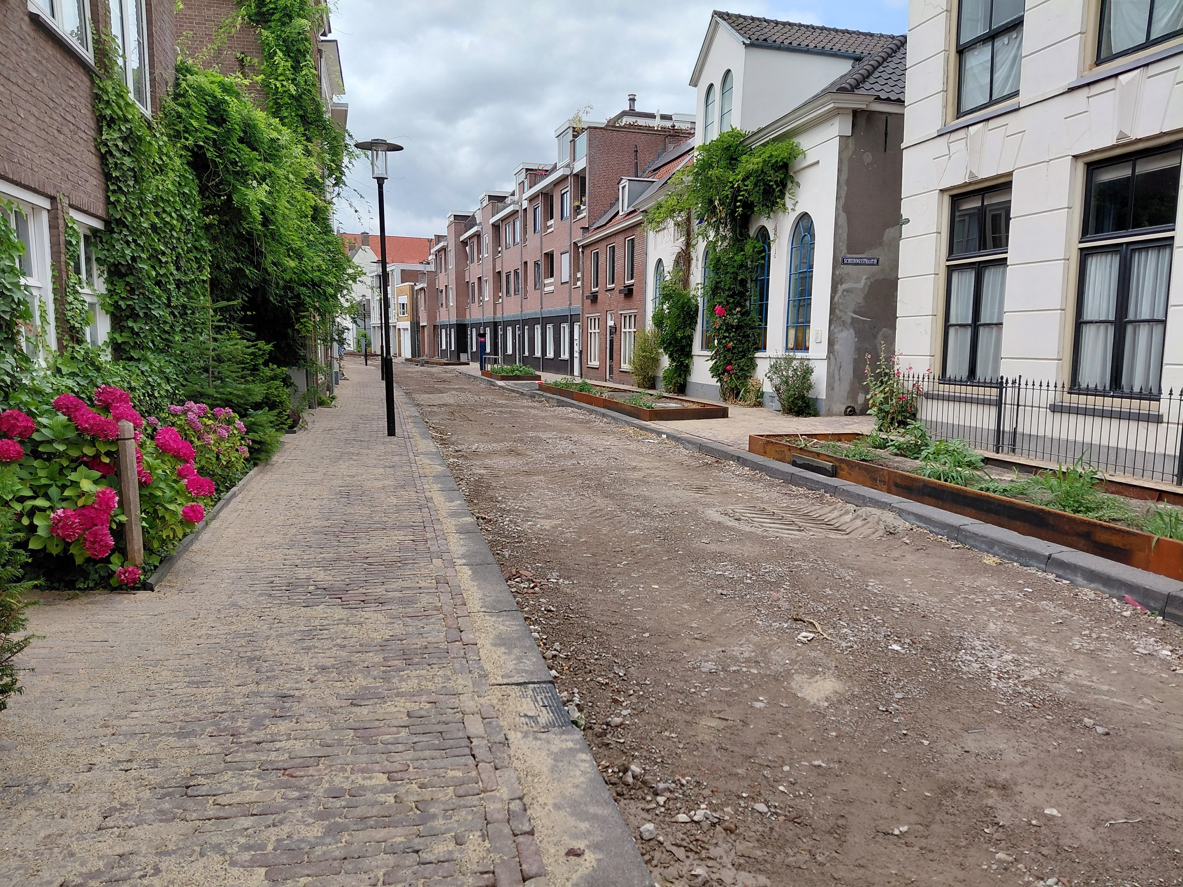 Op de afbeelding is de Gasthuisstraat te zien. De bestrating van de stoep zit erin, die van de weg nog niet.